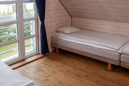 a small room with a bed and two windows at Domki Primore in Władysławowo