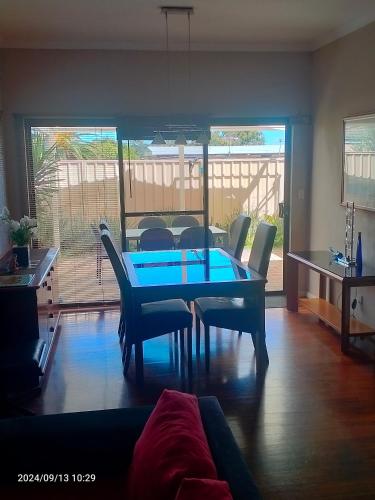 a dining room with a blue table and chairs at Palmyra Secure holidays Townhouse in Bicton