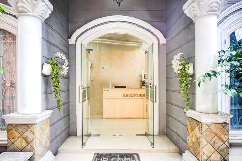 an entry way with an archway and a desk at OYO 94680 Ralica Residence in Medan