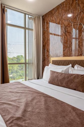 a bedroom with a large bed and a window at Hotel Tashree Near T3 - Free Airport Drop in New Delhi