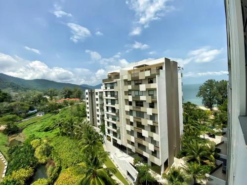 an apartment building with a view of the ocean at By The Sea Penang in Batu Ferringhi
