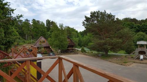 a wooden deck with a playground and a house at Saulrieti in Saulkrasti