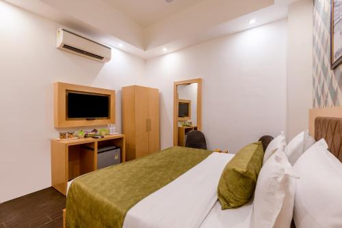 a hotel room with a bed and a tv at Hotel Tashree Near T3 - Free Airport Drop in New Delhi