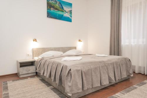 a bedroom with a bed with two towels on it at Vila Bradul in Lacu Rosu