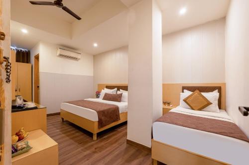 a hotel room with two beds and a bathroom at Hotel Tashree Near T3 - Free Airport Drop in New Delhi