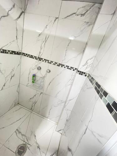 a white marble shower in a bathroom at Departamento #2 Aeropuerto Toluca in Toluca