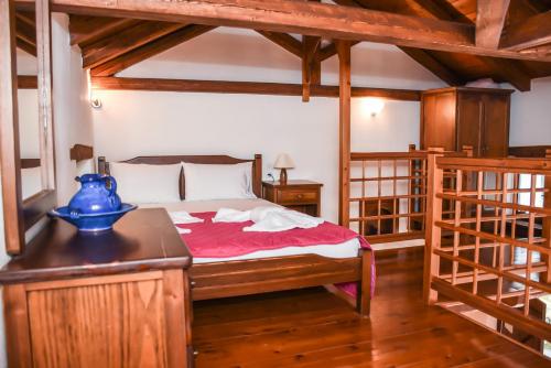 a bedroom with a bed with a blue vase on a table at erofili apartments in Kalamos