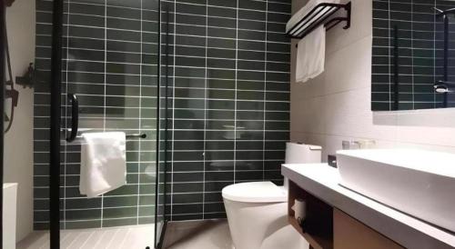 a bathroom with a shower and a toilet and a sink at Green Tree Inn Luoyang Fenghuang Mansion Mudan Square Metro Station in Luoyang