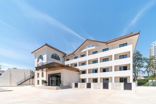a large white building with a blue sky in the background at Qinhuangdao Ansyn Resort Hotel in Qinhuangdao