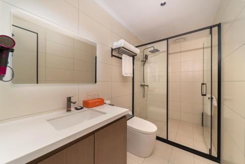 a bathroom with a sink and a toilet and a shower at Qinhuangdao Ansyn Resort Hotel in Qinhuangdao