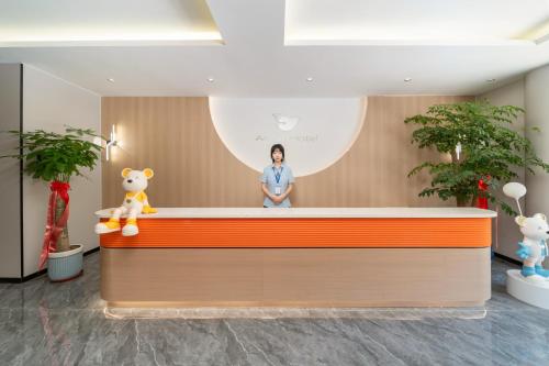 a woman standing behind a counter in a lobby at Qinhuangdao Ansyn Resort Hotel in Qinhuangdao