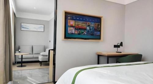 a bedroom with a bed and a living room at GreenTree Inn Express Qingdao Jiaodong International Airport in Qingdao