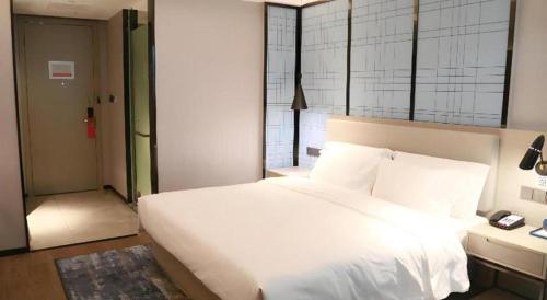 Ένα ή περισσότερα κρεβάτια σε δωμάτιο στο Echarm Hotel Huanggang Tuanfeng Administration Service Center