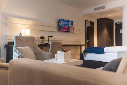 a hotel room with a bed and a living room at Hotel Novum in Hinte