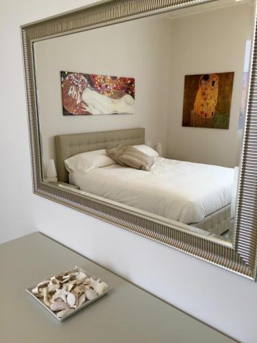 a bedroom with a large mirror on the wall at St. Vitale’s Basilic view elegant apartment in Ravenna