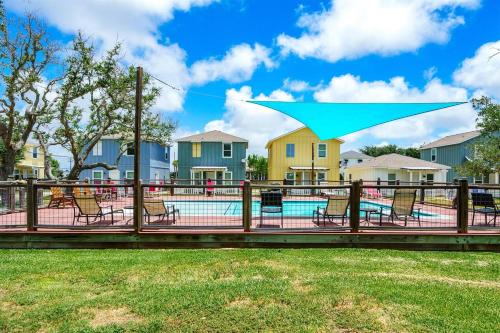 a pool deck with chairs and a blue umbrella at The Rockport Retreat Pool Access in Rockport