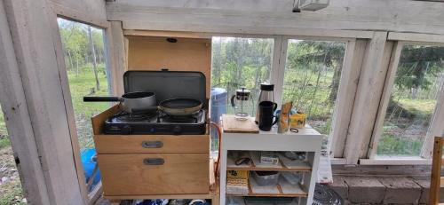 a kitchen with a stove and a counter with windows at Luxe tent met uitzicht op het bos en met Sauna en hottub 