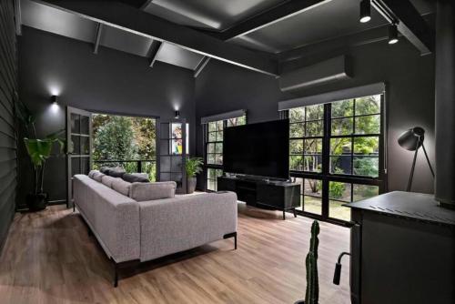 Una sala de estar con un sofá y un televisor de pantalla plana. en Eune House, en Broke