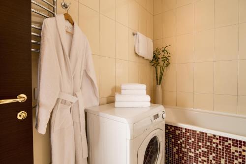 a bathroom with a washing machine and a towel at Senator Victory Square in Kyiv