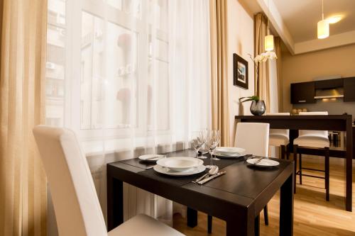 a dining room with a black table and white chairs at Senator Victory Square in Kyiv