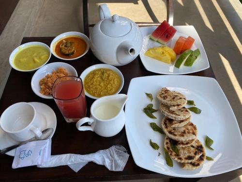 a table with plates of food and a teapot at Ella Mountain Inn in Ella
