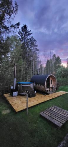 a yurt with a grill and a smoker on a wooden deck at Luxe tent met uitzicht op het bos en met Sauna en hottub 