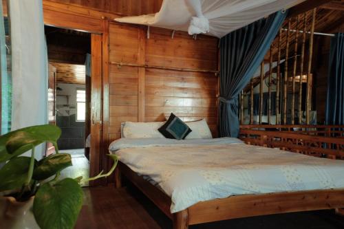 a bedroom with a bed with a wooden wall at Nương Homestay in Sa Pa