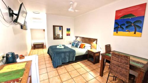 a bedroom with a bed and a table in a room at Rainforest Motel in Mission Beach