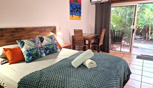 a bedroom with a bed and a table with chairs at Rainforest Motel in Mission Beach