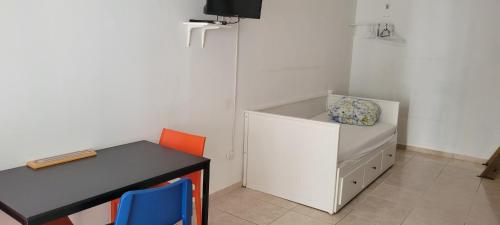 a small room with a desk and a table with a chair at Villa Colonial Room 7 in Río San Juan