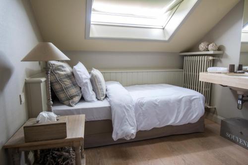 a bedroom with a bed with a skylight at Lebeaubylivingroom Hotel in Knokke-Heist