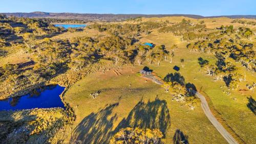 an aerial view of a house on a hill next to a river at Wuelf & the Fallow in Moonbah