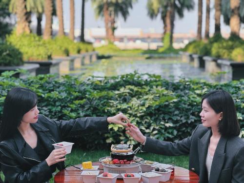 two women sitting at a table with a cake at Chateau Star River Guangzhou-Free Shuttle Between Hotel And Exhibition Center & Welcome Drink During Canton Fair in Guangzhou