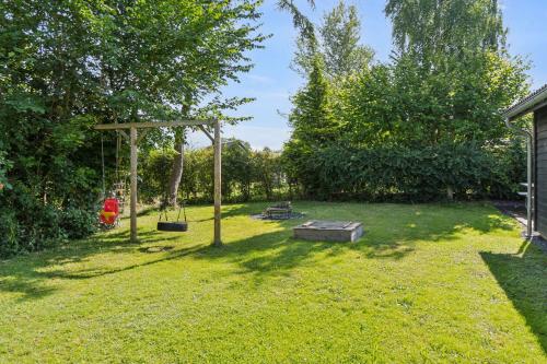 a yard with a swing and a picnic table at Lovely Summer House Close To Stillinge Beach in Slagelse