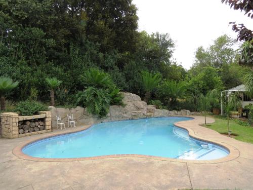 a large swimming pool in a yard with trees at Dunton Guest House in Johannesburg