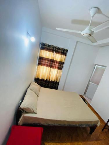 a small room with a bed and a window at The Curry Lodge - Thimbiriya in Habaraduwa