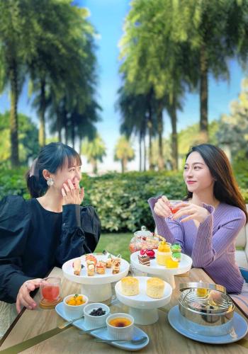 two women sitting at a table eating food at Chateau Star River Guangzhou-Free Shuttle Between Hotel And Exhibition Center & Welcome Drink During Canton Fair in Guangzhou