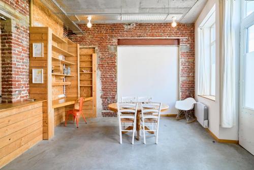 une pièce avec une table et des chaises et un mur de briques dans l'établissement Appartement 2 chambres atypique en souplex, à Lille