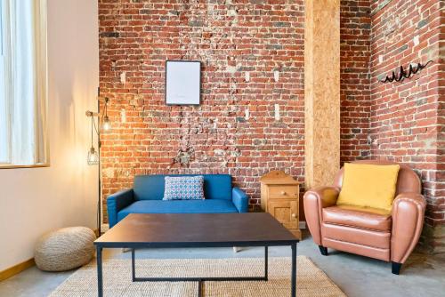 un salon avec un canapé bleu et une chaise dans l'établissement Appartement 2 chambres atypique en souplex, à Lille