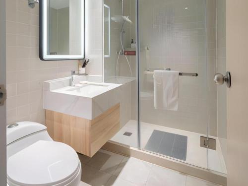 a bathroom with a shower and a toilet and a sink at Jinjiang Inn Quanzhou West Street Kaiyuan Temple in Quanzhou
