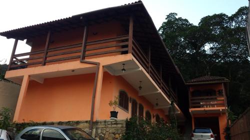 a house with a balcony on top of it at Hospedaria - Hostel Gamboa in Angra dos Reis