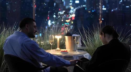 a man shaking the hand of a woman at a table at night at CS Premier Hotel in Seoul