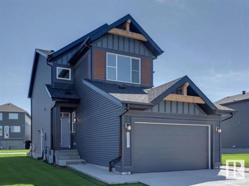a black house with a garage in front of it at Relax at The Hills at Ellerslie in Edmonton