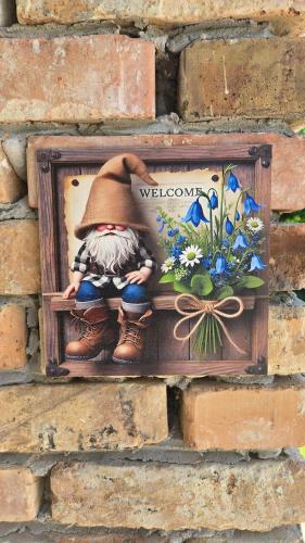 a figurine of a woman sitting on a shelf on a brick wall at Vörös Patak Apartmanház -Red Creek Apartmant House in Balatonfůzfő