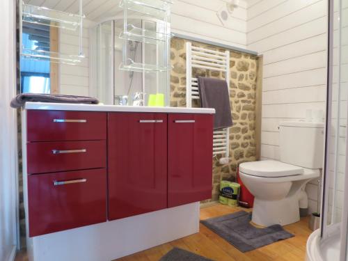 baño con armarios rojos y aseo en Au coeur de la baie en Le Val-Saint-Père