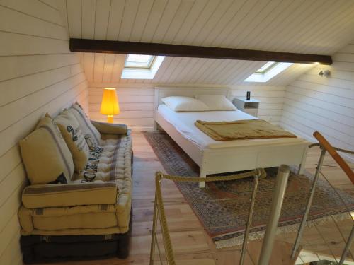 une chambre avec un lit et une chaise dans un grenier dans l'établissement Au coeur de la baie, à Le Val-Saint-Père