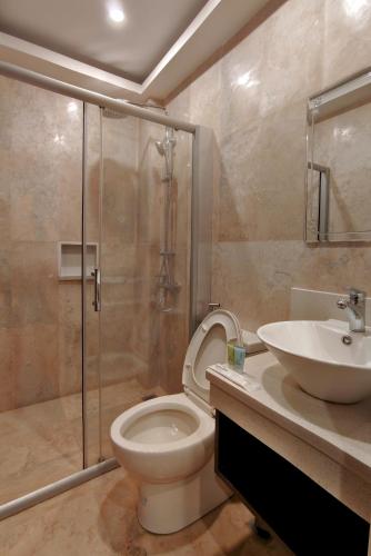 a bathroom with a shower and a toilet and a sink at Ambien's Place Residential Hotel in Dagupan