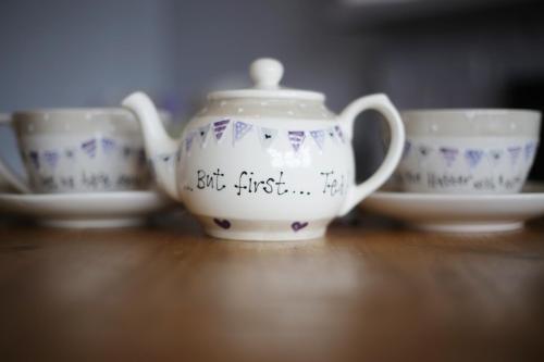 three cups and a tea pot sitting on a table at Sunrise Guest House in Bude