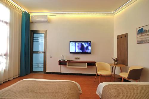 a room with two beds and a tv on the wall at First encounter with a homestay in Fenghuang