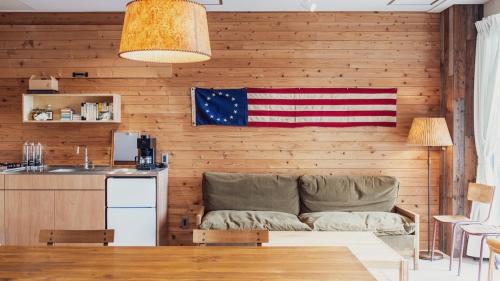 a living room with a couch and an american flag on the wall at 衣食住が楽しめるデザイナーズホテル E-YADO 新潟 Niigata in Niigata